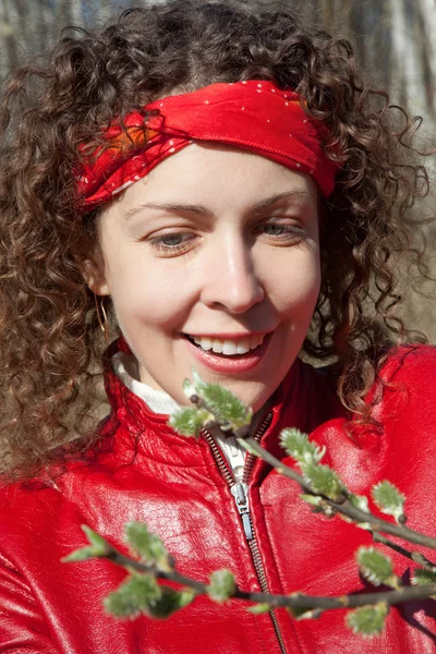 Das Mädchen in Rot blickt auf die volle Knospe im Frühlingspark — Stockfoto