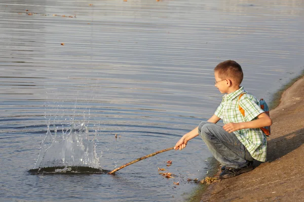 Мальчик возле пруда — стоковое фото