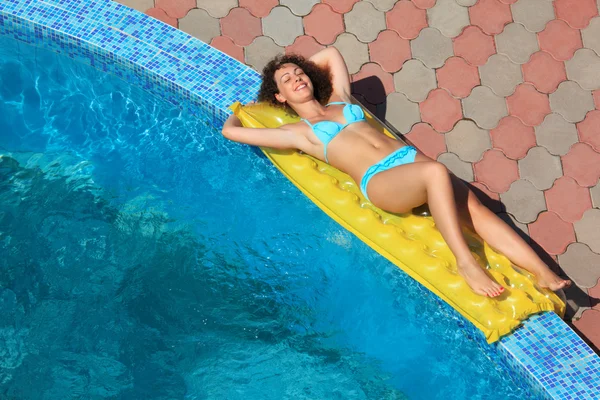 Mooie seksuele vrouw liggend op een opblaasbare matras in de buurt van zwembad — Stockfoto