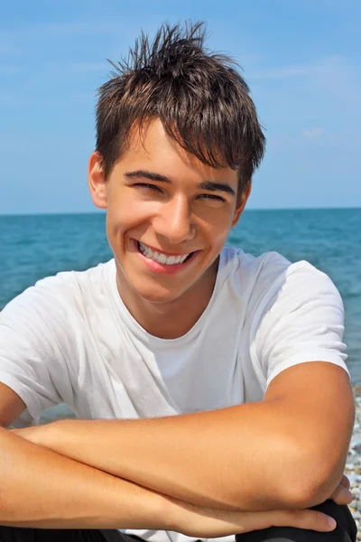 stock image Smiling teenager boy against sea, Looking at camera