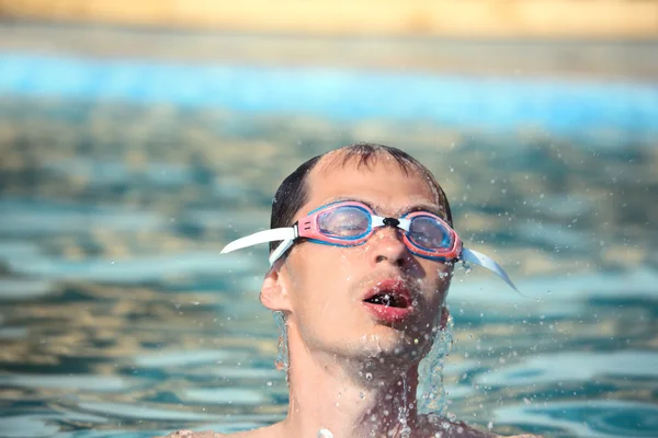 Joven en gafas de deporte acuático nadando en la piscina , — Foto de Stock
