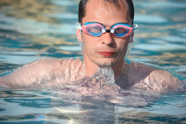 Ung man i watersport skyddsglasögon bada i pool — Stockfoto