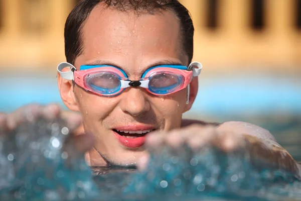 Ung man i watersport skyddsglasögon bada i pool, extended händer — Stockfoto
