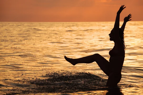 Silueta hermosa mujer jugar en el mar por la noche — Foto de Stock