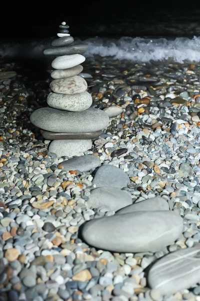 夜に石の海岸で小石からピラミッドします。 — ストック写真