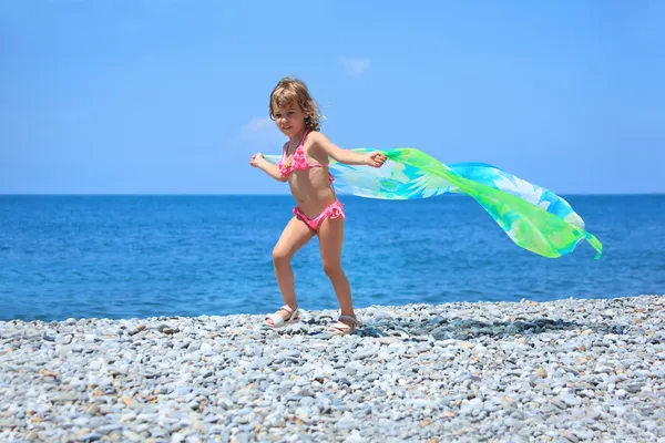 Bella bambina con tessuto sulla costa rocciosa — Foto Stock