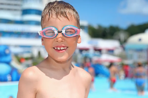 Niño en gafas de deporte acuático cerca de la piscina en el parque acuático de un entertaini —  Fotos de Stock