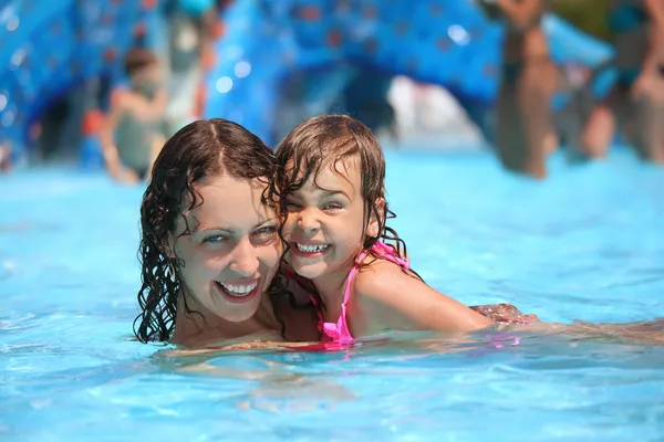 Glimlachen, mooie vrouw en meisje baadt in zwembad in aquapa — Stockfoto
