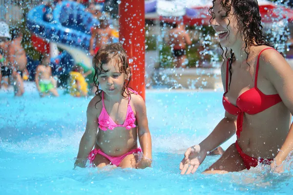 Sorridente bella donna e bambina si bagna in piscina sotto wat — Foto Stock