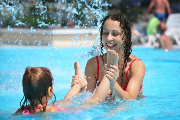 Sorrindo bela mulher e pequena menina banha-se na piscina sob wat — Fotografia de Stock