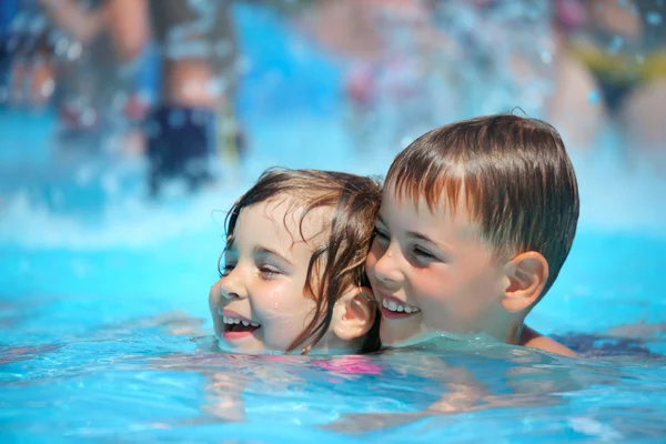 Smiling boy and little girl swimming in pool in aquapark — Stock Photo, Image