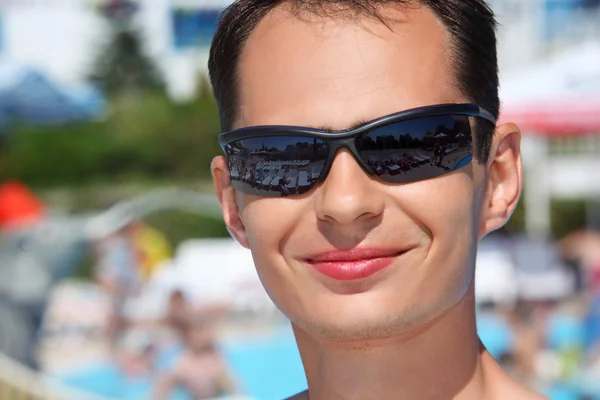 Aquapark içinde güneş gözlüğü gülümseyen genç adam — Stok fotoğraf