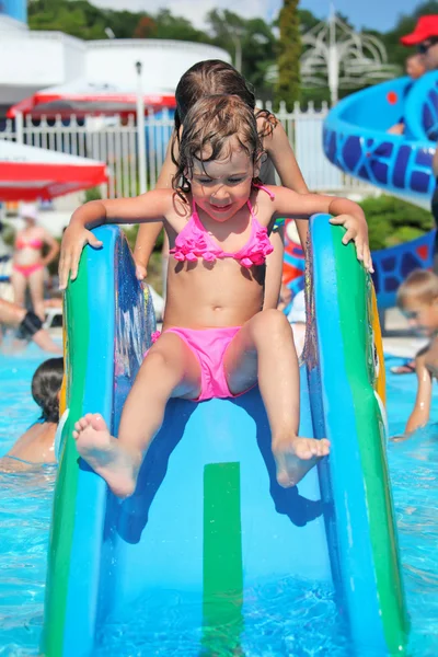 Całkiem mała dziewczynka idzie w dół na wzgórzu w aquaparku entertain — Zdjęcie stockowe