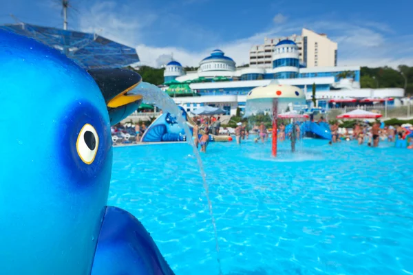 Fountain in form of toy dolphin near pool in aquapark — Stock Photo, Image