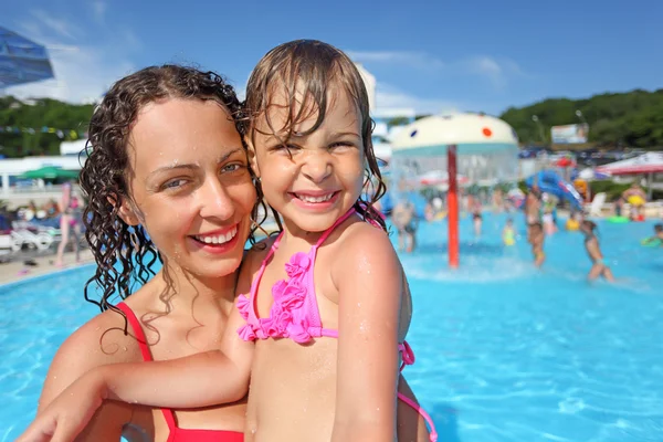 Smiling beautiful woman and little girl bathing in pool of an en — Stock Photo, Image