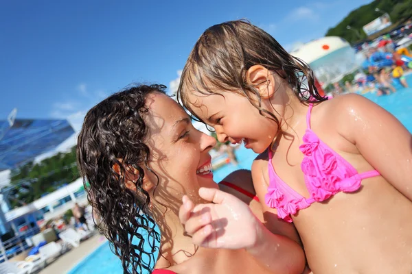 Smiling beautiful woman and little girl bathing in pool of an en — Stock Photo, Image