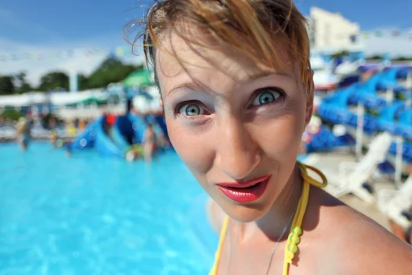 Удивлённая молодая женщина, стоящая в бассейне развлекательного компаньона — стоковое фото