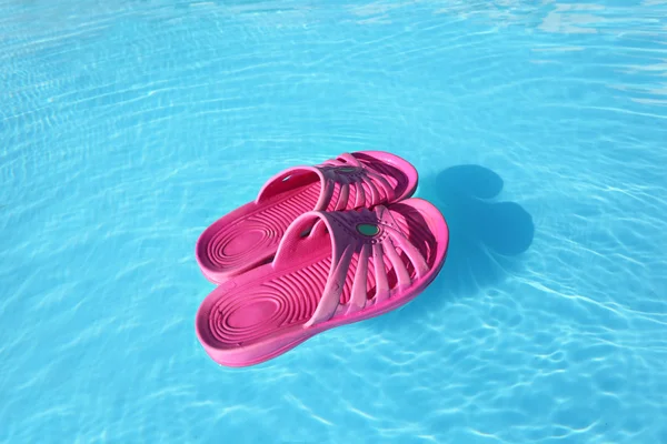 Strand slippers zwemmen op wateroppervlak in zwembad — Stockfoto