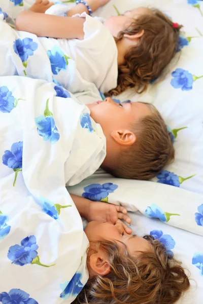 Παιδιά τριών μαζί κοιμάται σε κρεβάτι σε ζεστό δωμάτιο — Φωτογραφία Αρχείου