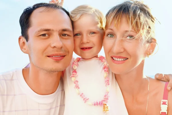 Щаслива сім'я з маленькою дівчинкою біля моря, що стосується голів — стокове фото