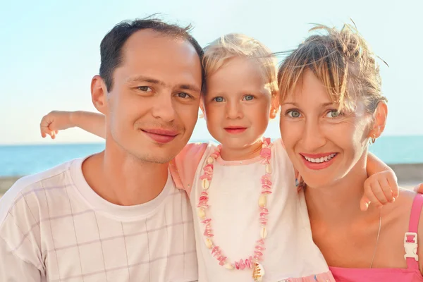 Ευτυχισμένη οικογένεια με μικρή κοντά στη θάλασσα — Φωτογραφία Αρχείου