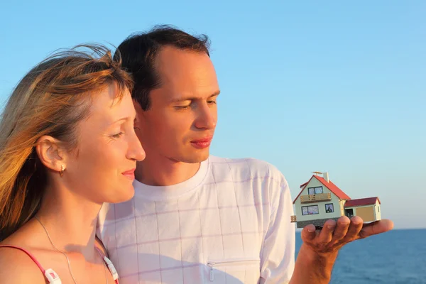 Молода жінка і чоловік тримає в руках модель будинку з гаражем — стокове фото