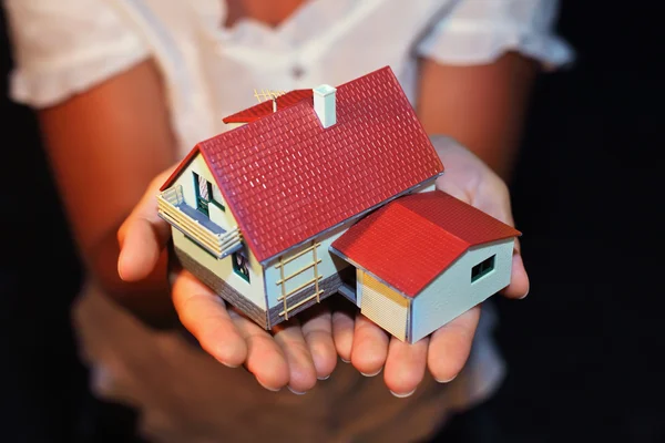 Model van huis met garage op handen — Stockfoto