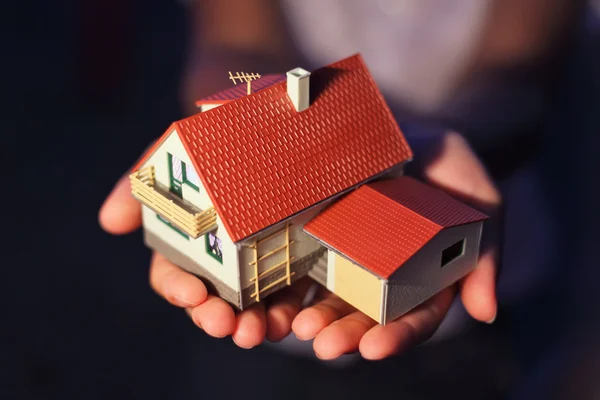 Modell eines Hauses mit Garage auf Händen — Stockfoto