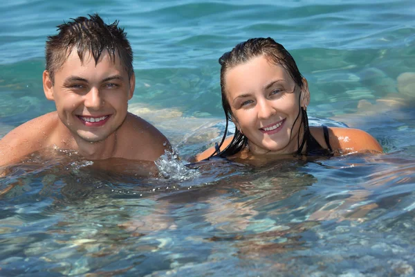 Young man and beautiful woman bathe in sea — Stock Photo, Image