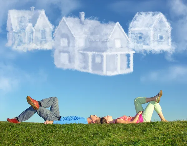 Pareja acostada en la hierba y sueño tres casas de nubes collage — Foto de Stock