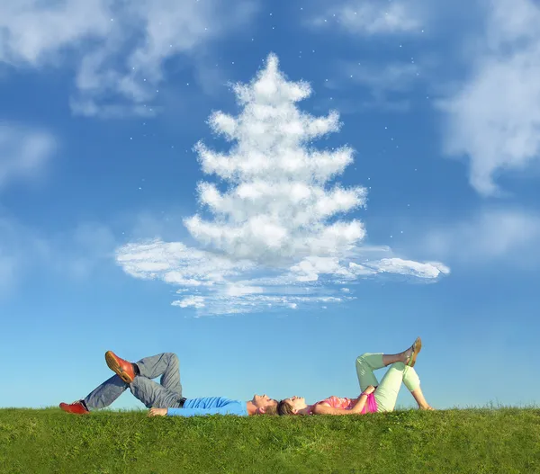 Lying couple on grass and dream christmas tree collage — Stock Photo, Image