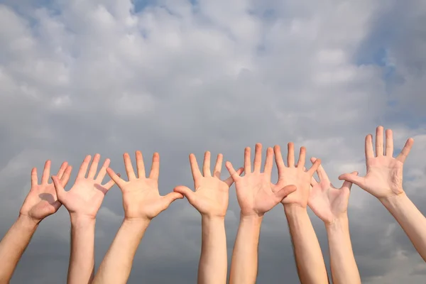 Verhoogde handen op bewolkte hemelachtergrond 2 — Stockfoto