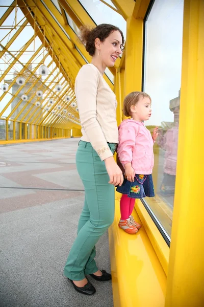 Mujer joven con bebé en puente peatonal —  Fotos de Stock