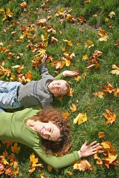 Donna con il figlio si sdraiano sull'erba — Foto Stock