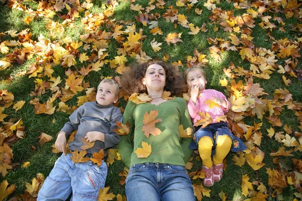 Mulher com o filho e a filha deitam-se na grama 2 — Fotografia de Stock