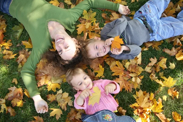 Woman with the son and the daughter they lie on the grass 3 — Stock Photo, Image