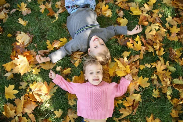 Girl and boy lie on the grass — Stockfoto