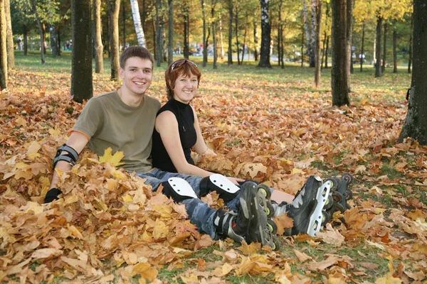 Young roller couple sit in park — Stock Photo, Image