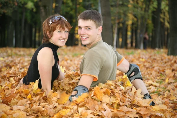 Молода пара сидить у жовтому листі — стокове фото
