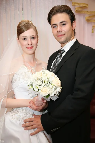 Verloofde met de bruid tegen de achtergrond van de gordijnen — Stockfoto