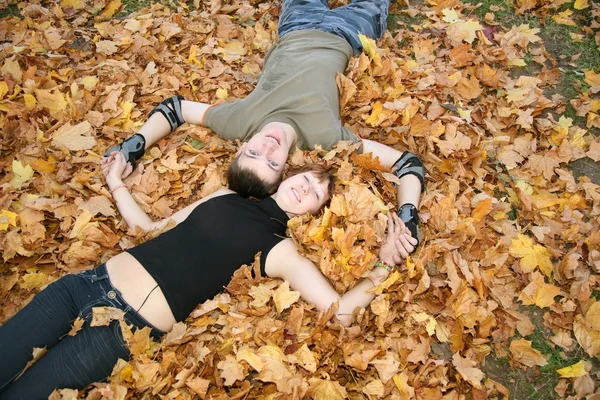 Young couple lies on yellow leaves 2 — Stock Photo, Image