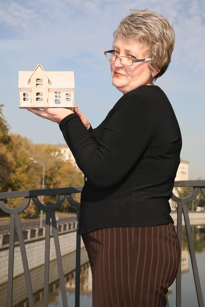 Senior vrouw met model van huis — Stockfoto