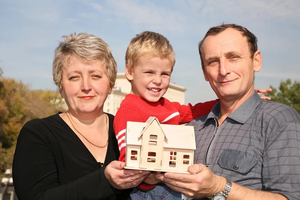 Großmutter und Großvater mit Enkel und Hausmodell — Stockfoto