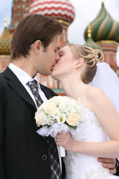 Bride and fiance are kissed against the background of temple Vasiliya Bless — Stock Photo, Image