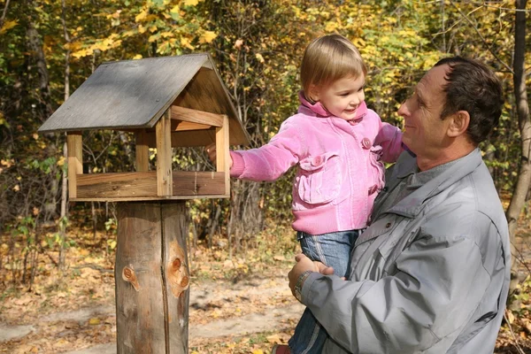 Grandfather with the granddaughter in the park in autumn — Stock Photo, Image