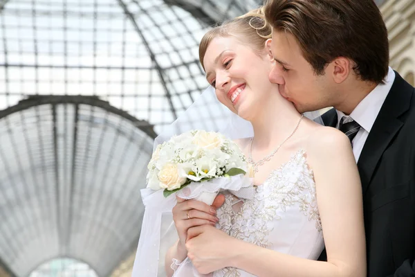 Noivo com a noiva, eles se beijam na passagem — Fotografia de Stock