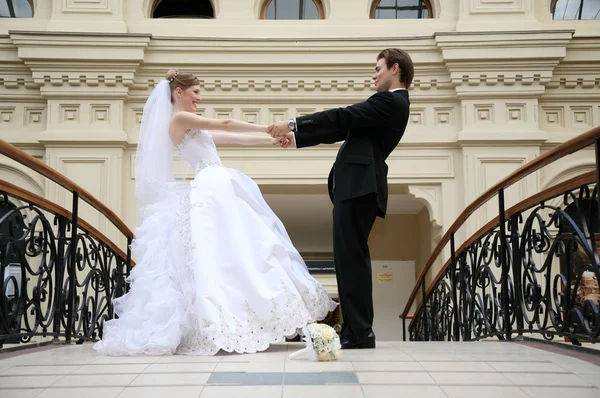 Fästman med bruden, de hålla varandra i händerna — Stockfoto