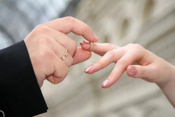 Рука, которая надевает кольцо на другую руку — стоковое фото