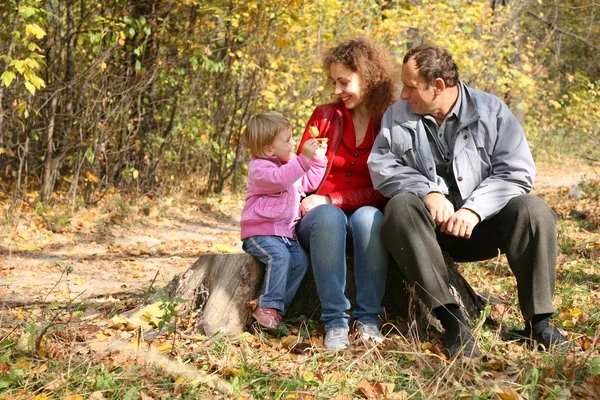Мати з дочкою і дідусем в парку восени — стокове фото