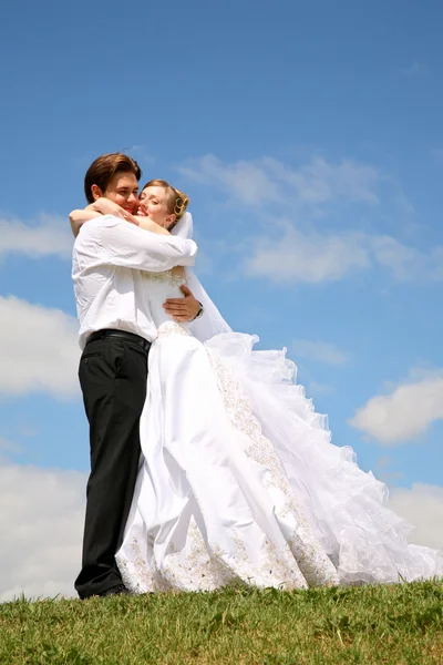 Noivo com a noiva eles são abraçados no prado — Fotografia de Stock